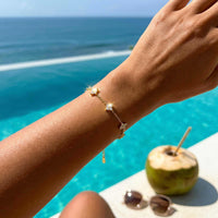 Thumbnail for Crystal Flower Bracelet by Brother & Sisters featuring five sparkling crystal flowers on a wrist by the pool.
