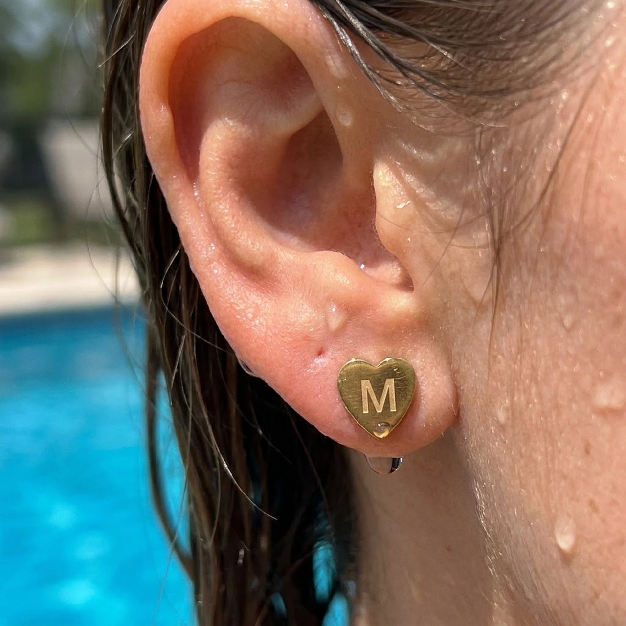 Heart Initial Stud Earrings in Gold worn in a swimming pool, waterproof 304L stainless steel | SKU: heart-initial-gold-a