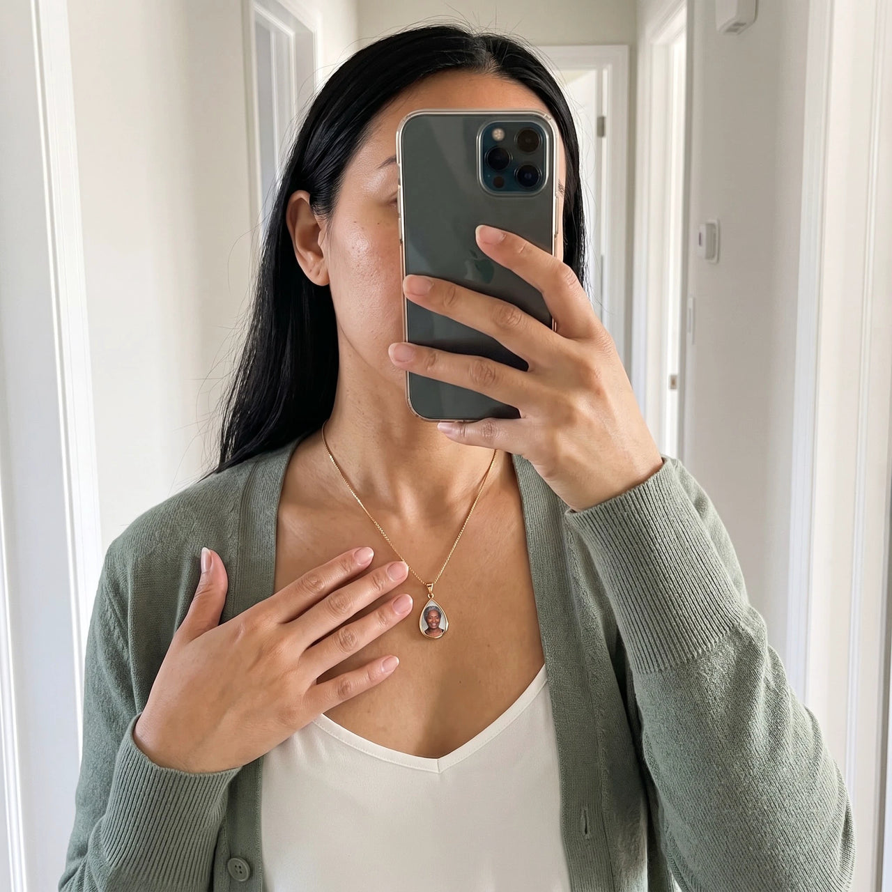 Mirror selfie of a woman in a green cardigan wearing the gold secret drop photo necklace | SKU: TPH-DRPN-GOLD